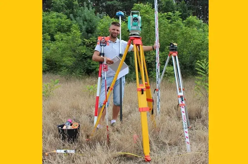 geodeta z tachimetrem w terenie
